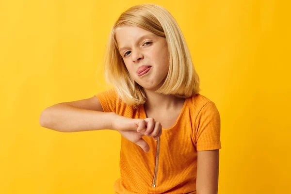 Schattig klein meisje met blond haar gebaseerd kindertijd gele achtergrond — Stockfoto