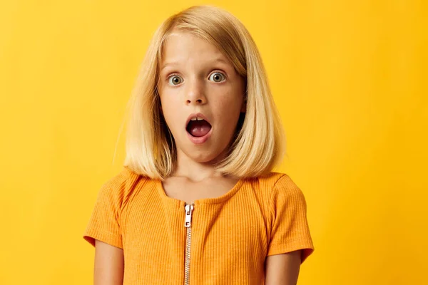 Cute little girl with blond hair based childhood yellow background — 图库照片
