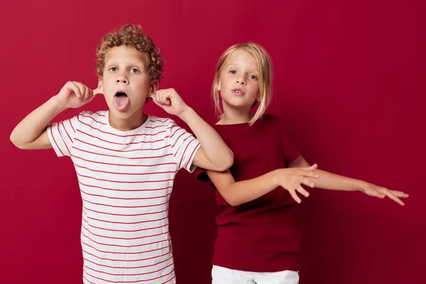 Два радостных ребенка эмоции стоят бок о бок в повседневной одежде на цветном фоне — стоковое фото