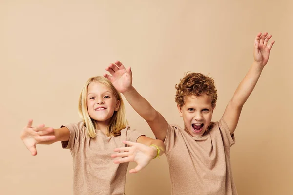 Kleine jongen en meisje in beige t-shirts poseren voor plezier jeugd ongewijzigd — Stockfoto