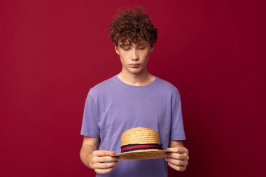 Genç adam gündelik kıyafetlerle kızıl saçlı. Gençlik stili, kırmızı arka plan değiştirilmemiş.