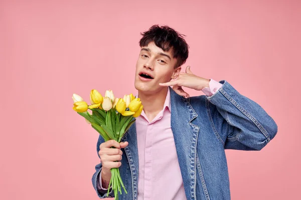 Pěkný muž v džínové bundě s kyticí květin dárek romantika dovolená beze změny — Stock fotografie