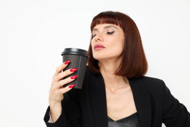 Siyah takım elbiseli çekici bir kadın içki büyüsü olan bir kupa değişmemiş bir yaşam tarzı