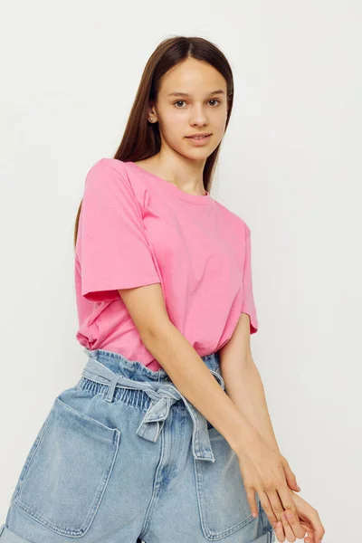 Mulher positiva em uma camiseta rosa roupas casuais fundo rosa — Fotografia de Stock