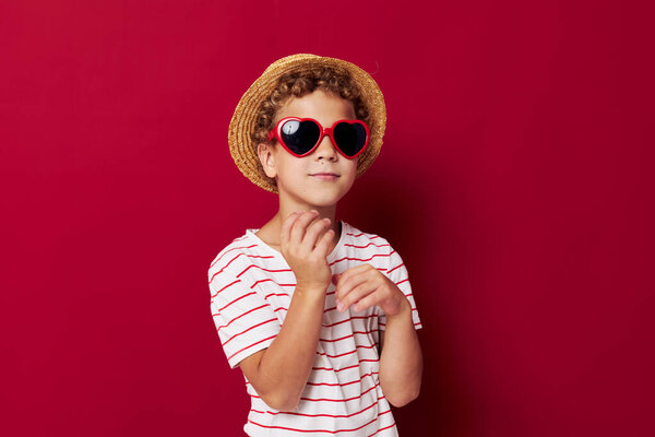 boy wearing sunglasses wearing a hat posing childish style