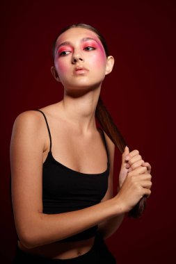 Genç, güzel bir kadın gülümseme makyaj çekici pembe arka plan değişmemiş görünüyor