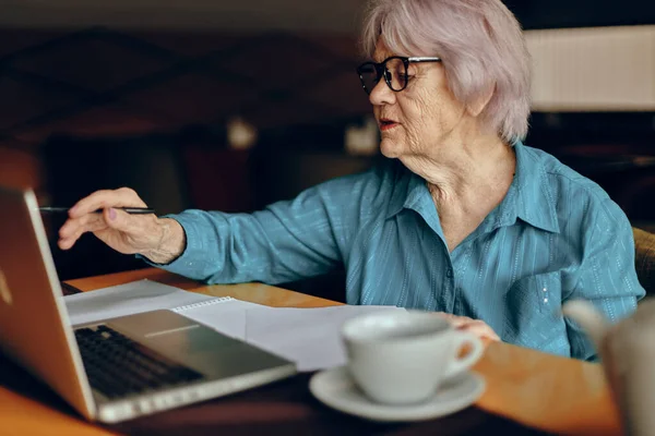 Красива зріла старша жінка, що працює перед монітором ноутбука, сидить у відставці — стокове фото