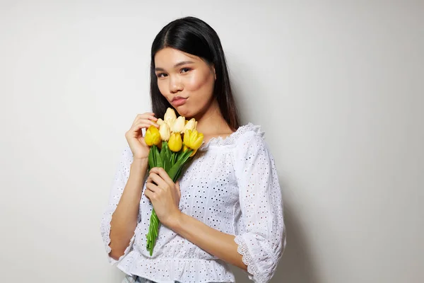 Žena s asijským vzhledem v bílé košili květiny jaro představovat studio model beze změny — Stock fotografie