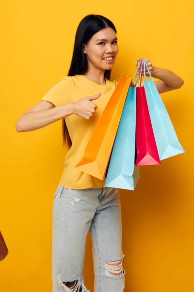 Vrouw met pakketten in handen winkelen geïsoleerde achtergrond ongewijzigd — Stockfoto