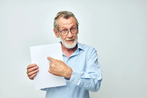 Портрет пожилого человека в синей рубашке и очки белый лист бумаги неизменным — стоковое фото