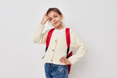 Küçük kız el hareketi kırmızı sırt çantası ışık arka plan