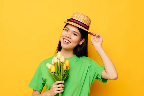 연두색 옷을 입고 변경되지 않은 모자의 노란 배경에 노란 꽃들 이 꽃다발을 이룬 여성 녹색 티셔츠 — 스톡 사진