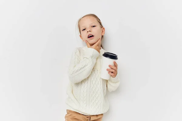 Bambina in vetro maglione bianco con bevanda sfondo chiaro — Foto Stock