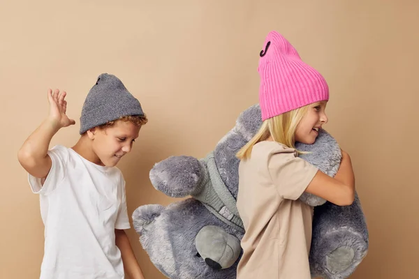 Little boy and girl in hats with a teddy bear friendship Lifestyle unaltered — Fotografia de Stock