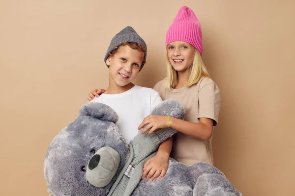 Leuke stijlvolle kinderen in hoeden met een teddybeer vriendschap Lifestyle onveranderd — Stockfoto