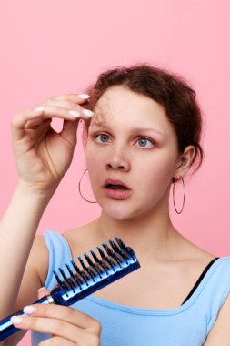 Çekici kadın taraktaki kılları çıkarıyor tatminsizlik pembe arka plan değiştirilmemiş