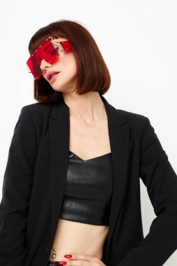 Kırmızılı güzel bir kadın şık gözlüklü, deri ceketli, siyah ceketli, hayat tarzını değiştirmemiş.