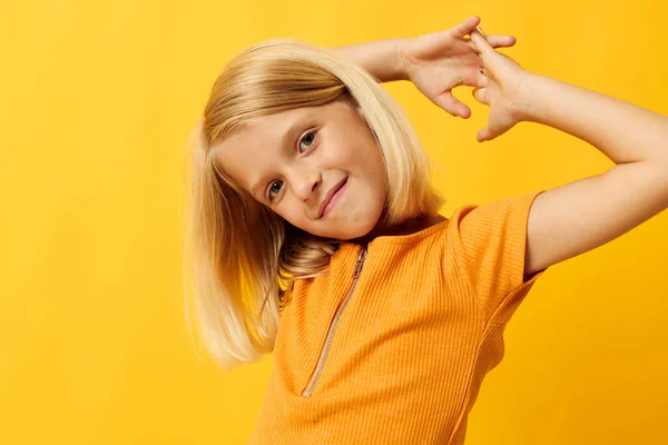 Güzel küçük kız gülümse el hareketlerin gelişigüzel poz ver eğlenceli sarı arka plan değişmeden giyin — Stok fotoğraf