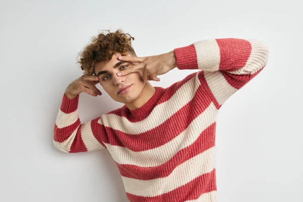 Pohledný mladý muž v pruhovaném svetru pózuje životní styl beze změny — Stock fotografie