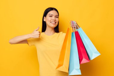 Asyalı görünümlü kadın moda alışverişi, soyutlanmış arka planda değişiklik yok.