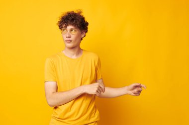 Kıvırcık saçlı genç adam. Gençlik tarzı gözlükler. Günlük kıyafet.