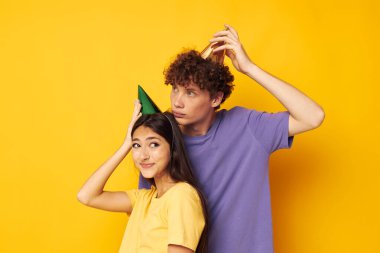 Bir erkek ve bir kız sarı arka planda sarılıyorlar.