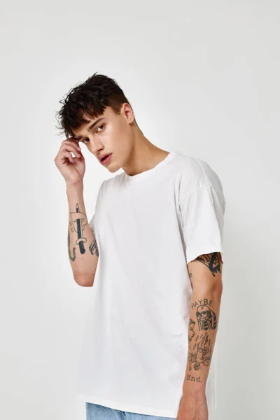 Photo young boyfriend modern youth style white t-shirt tattoo on the arm model studio — Fotografia de Stock