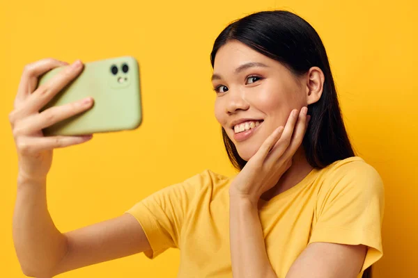 Funny asian girl with a phone in her hands makes a selfie — Foto Stock