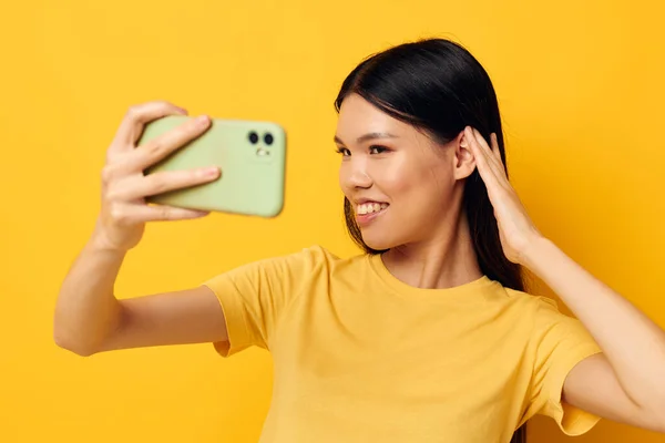 Γοητευτική νεαρή Ασιάτισσα γυναίκα με ένα smartphone στα χέρια διασκεδαστικά συναισθήματα κοντινό πλάνο Lifestyle αναλλοίωτο — Φωτογραφία Αρχείου