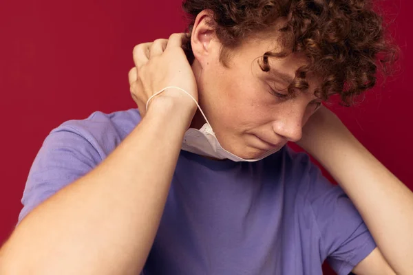 Un joven protección máscara médica posando fondo rojo inalterado —  Fotos de Stock