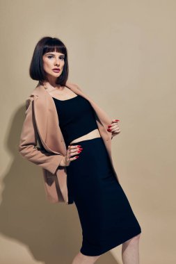 Çekici kadın kısa saçlı takım elbiseli, el hareketleriyle hayat tarzını değiştirmemiş.