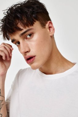 Yakışıklı adam, modern gençlik tarzı beyaz tişört dövmesi arkaplanda değiştirilmemiş.