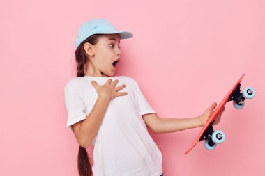 Çocukluğunda elinde kaykayla gezen sevimli bir kız.