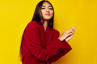 Kırmızı ceketli güzel esmer. Kozmetik gülümsemeli. Stüdyo modeli değişmemiş.