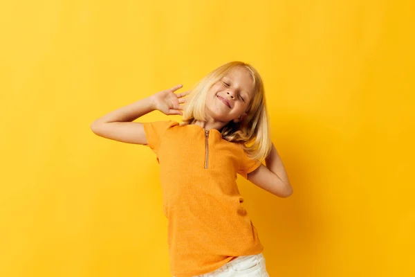 Красивая маленькая девочка в желтой футболке улыбается позируя студийный образ жизни детства неизменным — стоковое фото