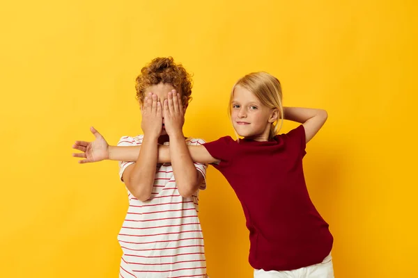 Мальчик и девочка повседневной одежды игры весело вместе желтый фон — стоковое фото