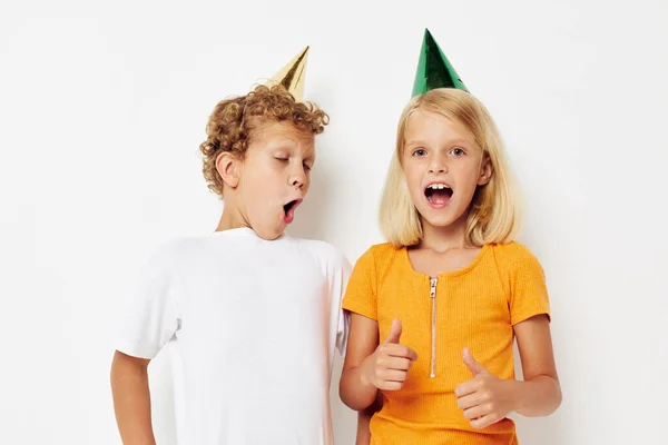 Cute stylish kids posing emotions holiday colorful caps isolated background unaltered — Stock fotografie