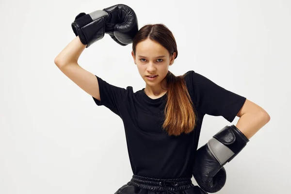 Joven hermosa mujer en guantes de boxeo en el suelo en negro entrenamiento de fitness camiseta — Foto de Stock