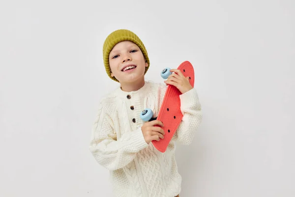 Little girl in hats with a skateboard in their hands childhood unaltered — Stock fotografie