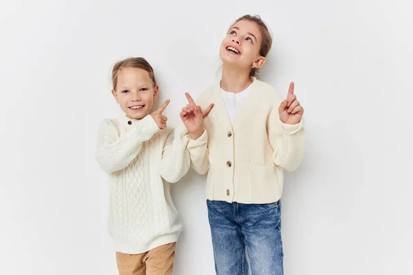 Две маленькие девочки в свитерах, изображающие веселье дружбы — стоковое фото