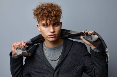 Ceketli yakışıklı bir adam, kareli bir eşarp, izole edilmiş bir arka plan.