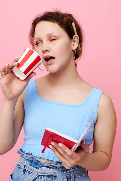 Young woman with notepad drinking disposable glass unaltered — Stockfoto
