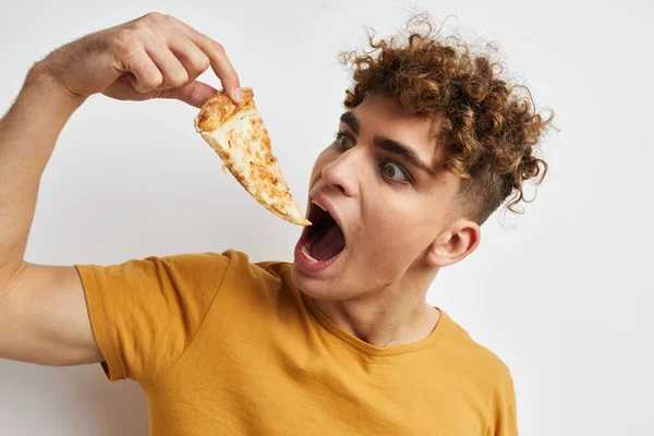 Attractive man eating pizza posing close-up isolated background — ストック写真