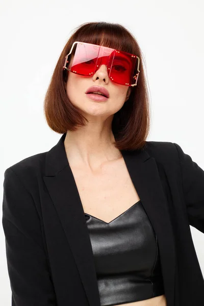 黒のジャケットの美しい女性赤のネイルポリッシュファッショングラスライトバックグランド — ストック写真