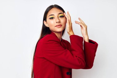 Güzel esmer, parlak makyajlı, kırmızı ceketli. Stüdyo modelini değiştirmemiş.