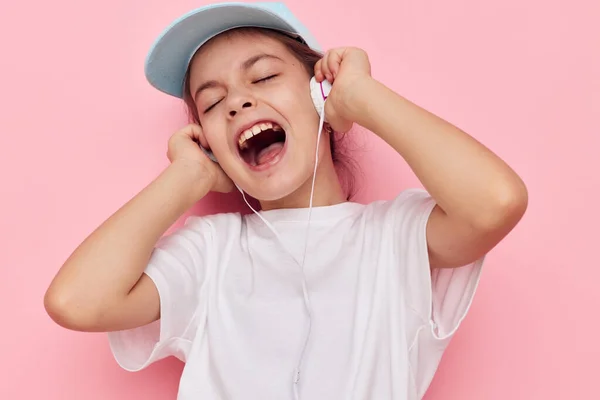 Porträt eines glücklich lächelnden Kindermädchens mit Kopfhörern, das Emotionen in der Kindheit unangetastet lässt — Stockfoto