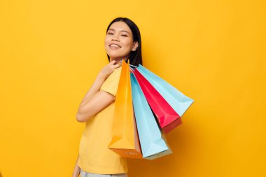 El alışverişinde paketleri olan Asyalı güzel bir genç kadın portresi. Stüdyo modeli değişmemiş.