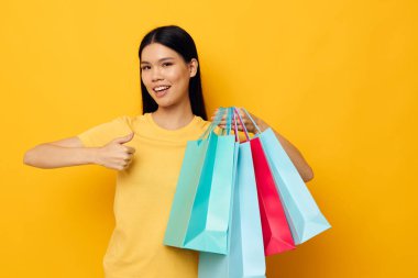 Asyalı görünümlü kadın moda alışverişi, soyutlanmış arka planda değişiklik yok.