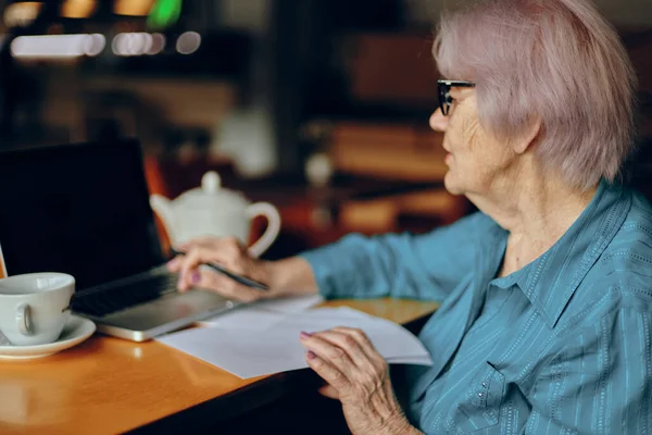 Портрет літньої жінки, що працює перед монітором ноутбука, що сидить Стиль життя незмінний — стокове фото