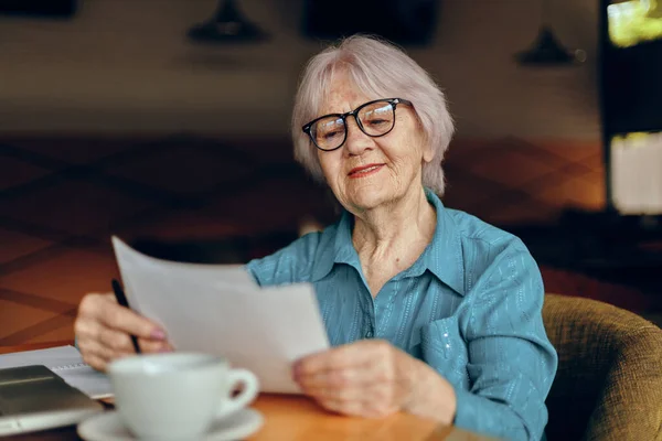 Una mujer de negocios que trabaja delante de un monitor portátil sentada Mujer jubilada charlando inalterada — Foto de Stock